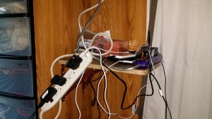 Two power strips on a shelf with lots of wires connected