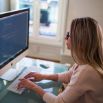 Lady typing at computer working on starting a LLC in Wisconsin
