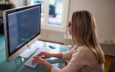 Lady typing at computer working on employee payroll