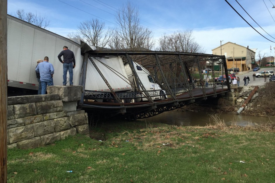 side view of semi truck and trailer collapsing bridge