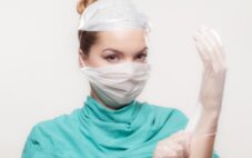 Doctor in surgery gear with face mask and plastic gloves on
