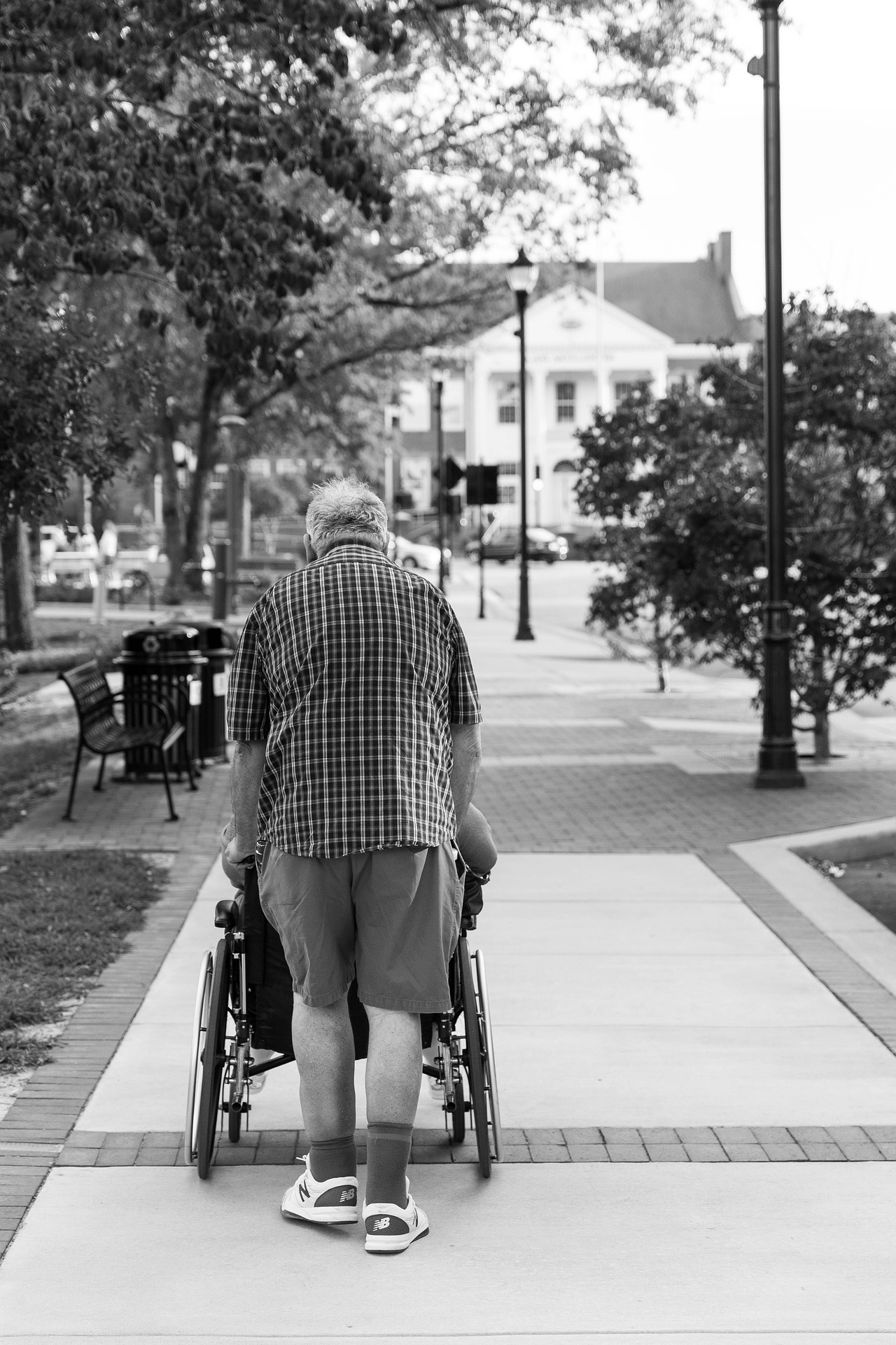 NEMT-non-emergency-medical-transportation-provider-pushing-person-in-wheelchair NEMT driver pushing a person in a wheelchair