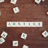 scrabble letters spelling out the word justice to reflect what attorneys do for clients