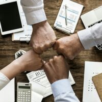 family employees group fist bumping each other